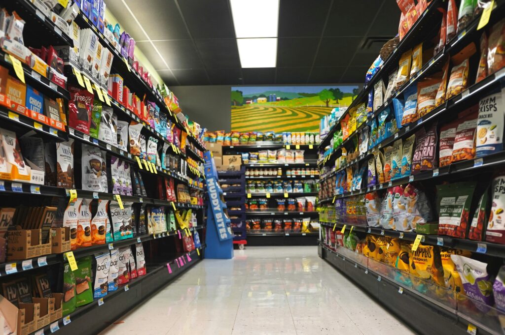Retail store aisle with stocked shelves showing products across categories, representing inventory management in a multi-location business
